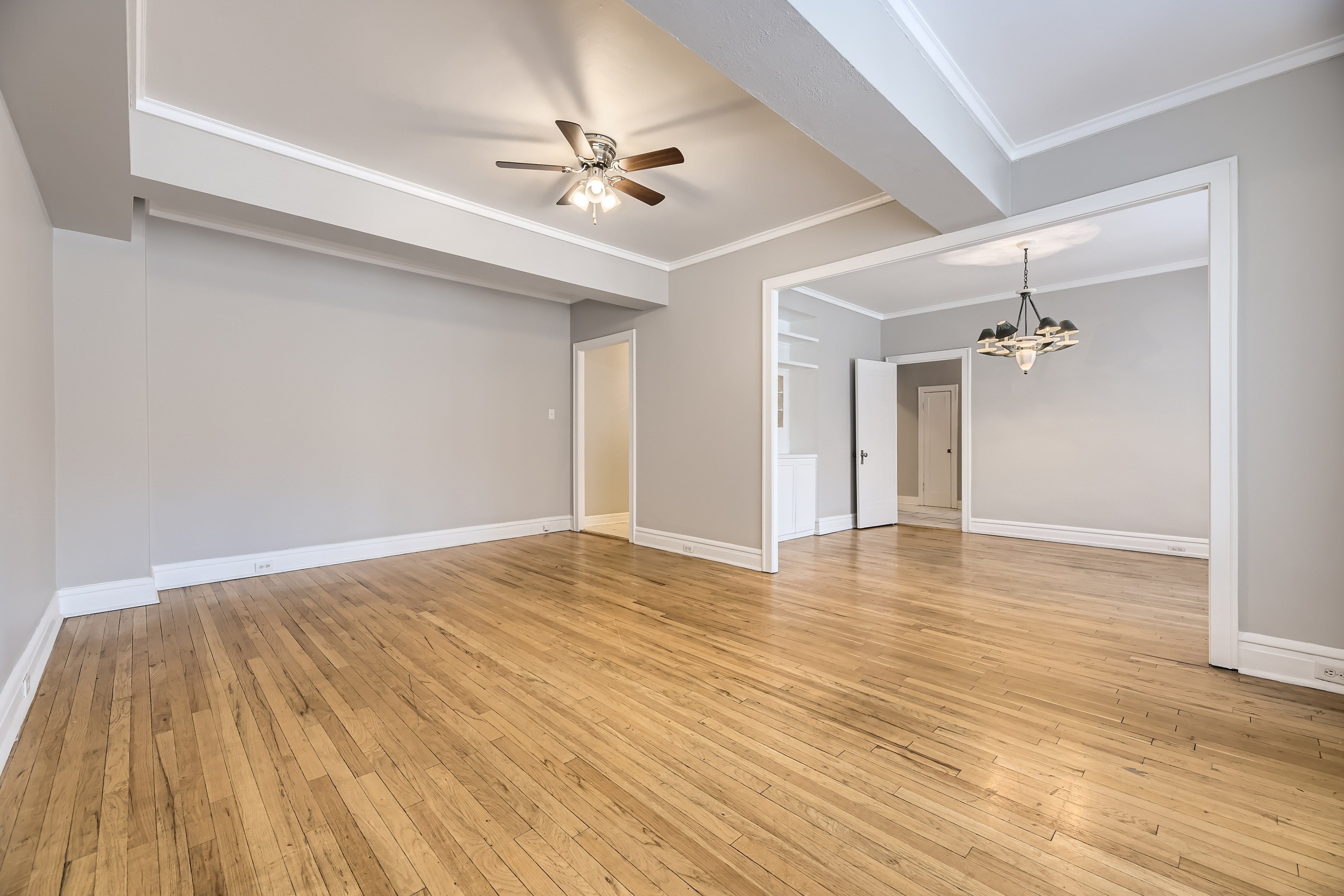 A room with wooden floors and a ceiling fan.